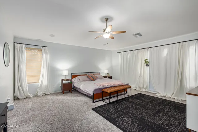 a bedroom with a bed chandelier and a window