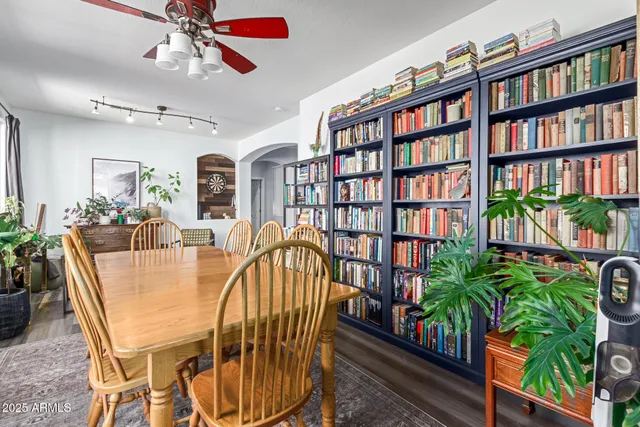 a dining room with furniture potted plants and wooden floor