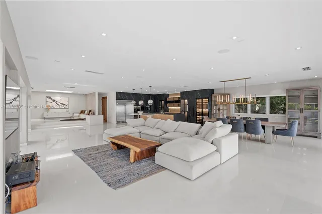 a living room with fireplace furniture and a view of kitchen