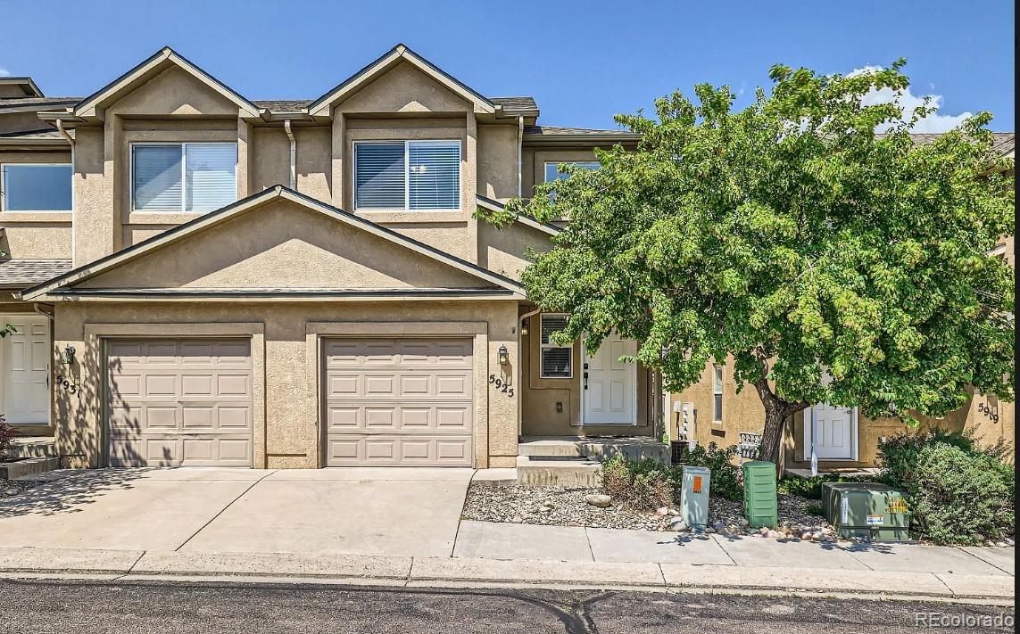 5925-5943 University Village View Colorado Springs, CO 80918 - Photo 1 of 21 a front view of a house with a yard and garage
