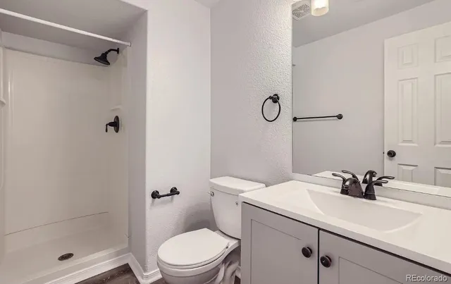 a bathroom with a sink a toilet and shower