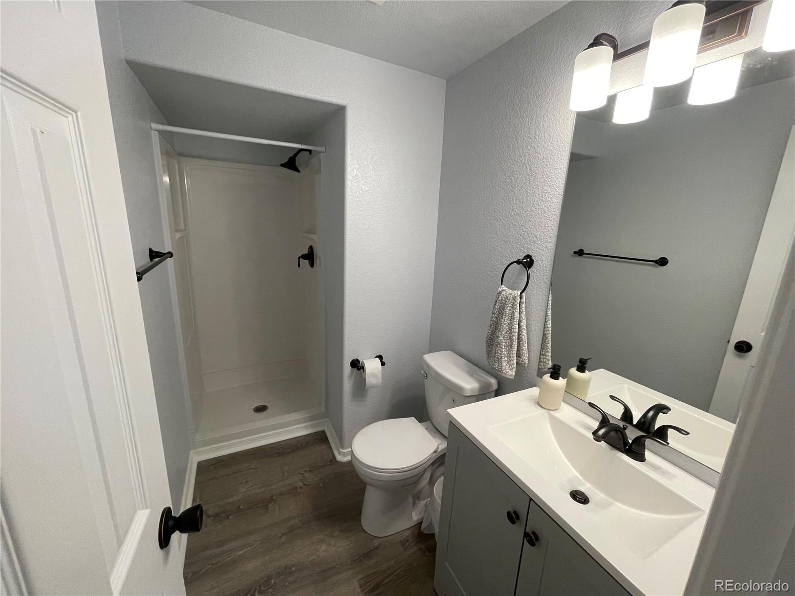 5925-5943 University Village View Colorado Springs, CO 80918 - Photo 20 of 21 a bathroom with a toilet a sink and mirror