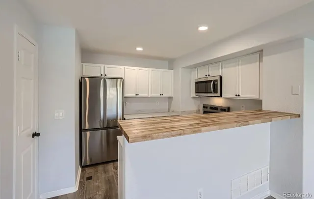 a kitchen with stainless steel appliances cabinets a refrigerator and a sink
