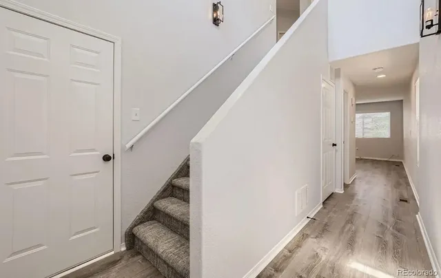 a view of a hallway with wooden floor and staircase