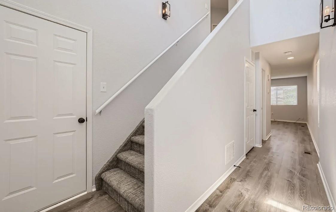 5925-5943 University Village View Colorado Springs, CO 80918 - Photo 10 of 21 a view of a hallway with wooden floor and staircase