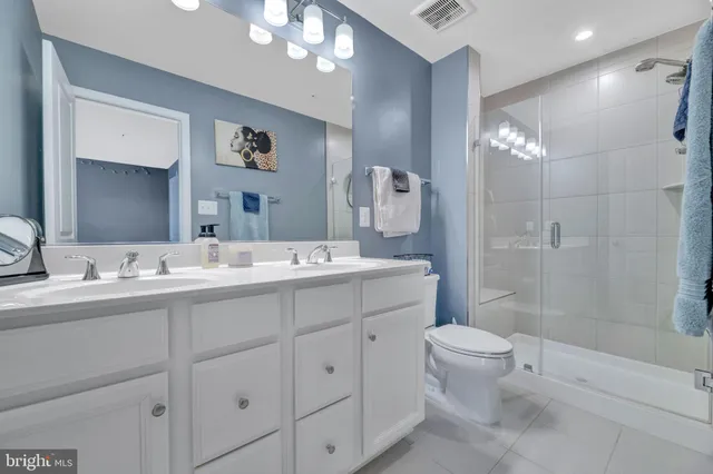 a bathroom with a double vanity sink toilet and shower