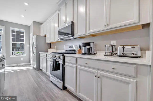 a kitchen with stainless steel appliances granite countertop a stove a sink and a refrigerator