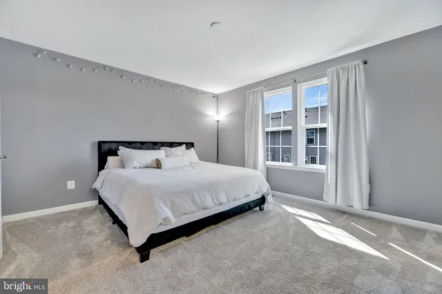 a large bed sitting in a room next to a window