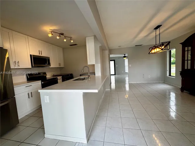 a view of a kitchen with cabinets and flat screen tv