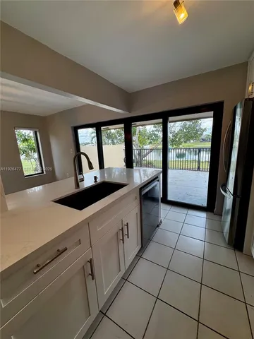 a large white kitchen with a large window