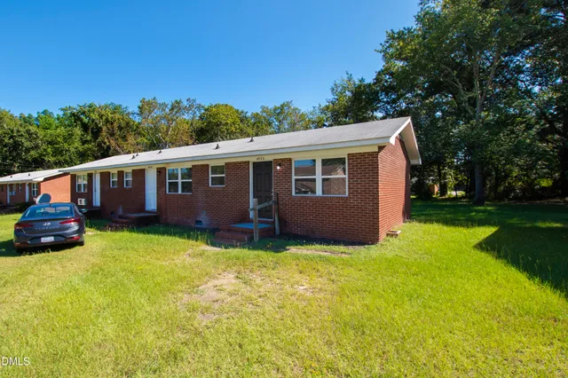 a view of a house with a yard and a tree