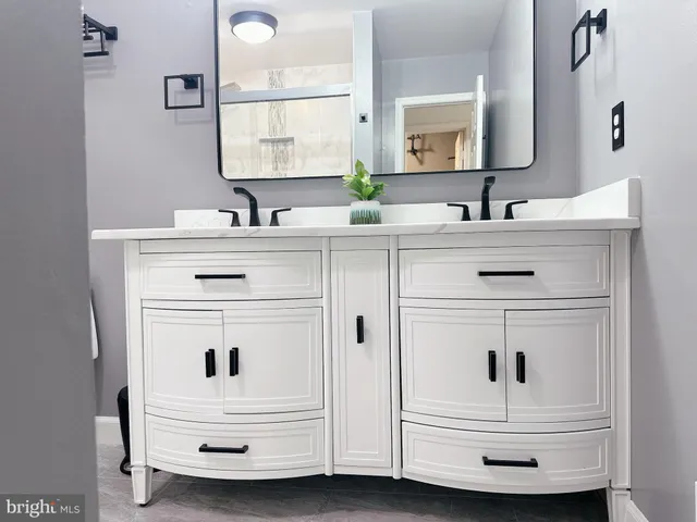 a bathroom with a sink vanity and mirror