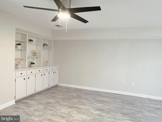 an empty room with chandelier fan
