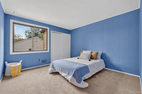 a bedroom with a bed and painting on the wall