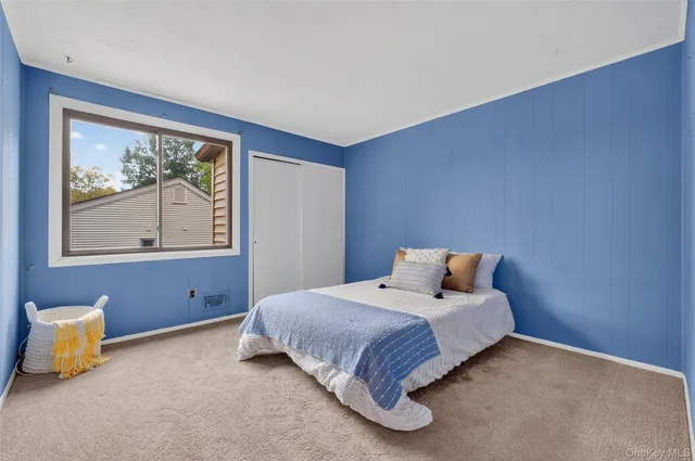 a bedroom with a bed and painting on the wall
