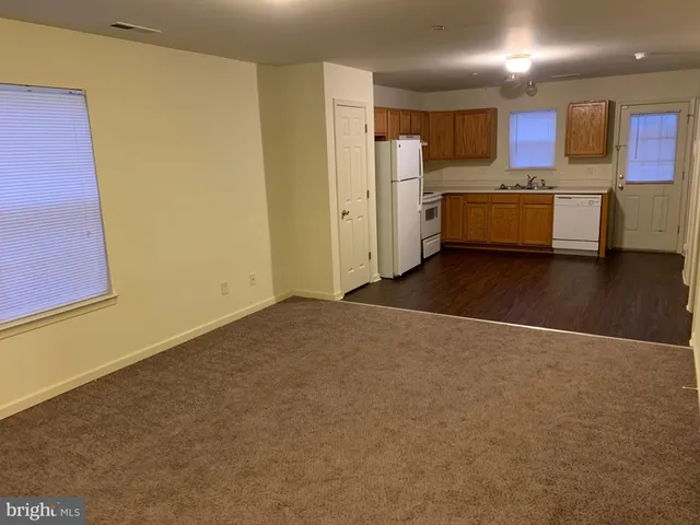 a view of a kitchen with wooden floor and a refrigerator