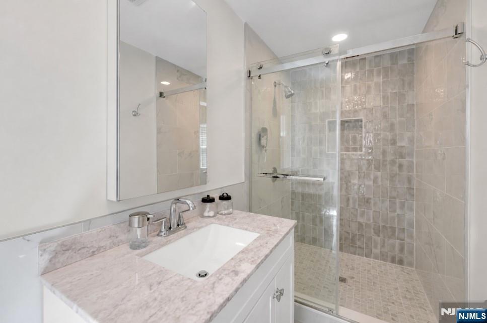 433 Piermont Road Cresskill, NJ 07626 - Photo 18 of 49 a bathroom with a granite countertop sink shower mirror and a bathtub
