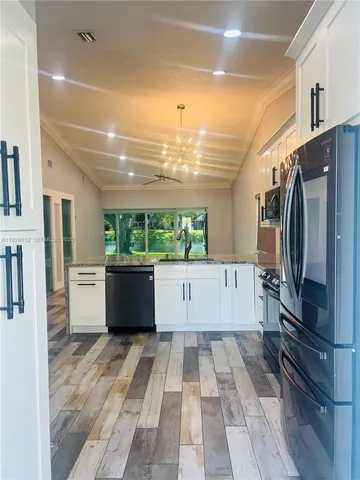 a view of kitchen with refrigerator and window