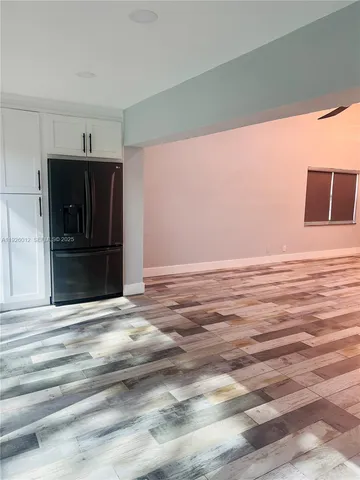 a view of an empty room with a fireplace and a window