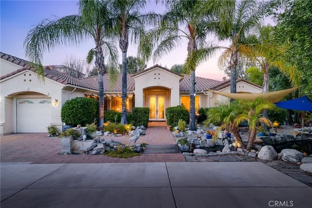 a front view of a house with garden and plants