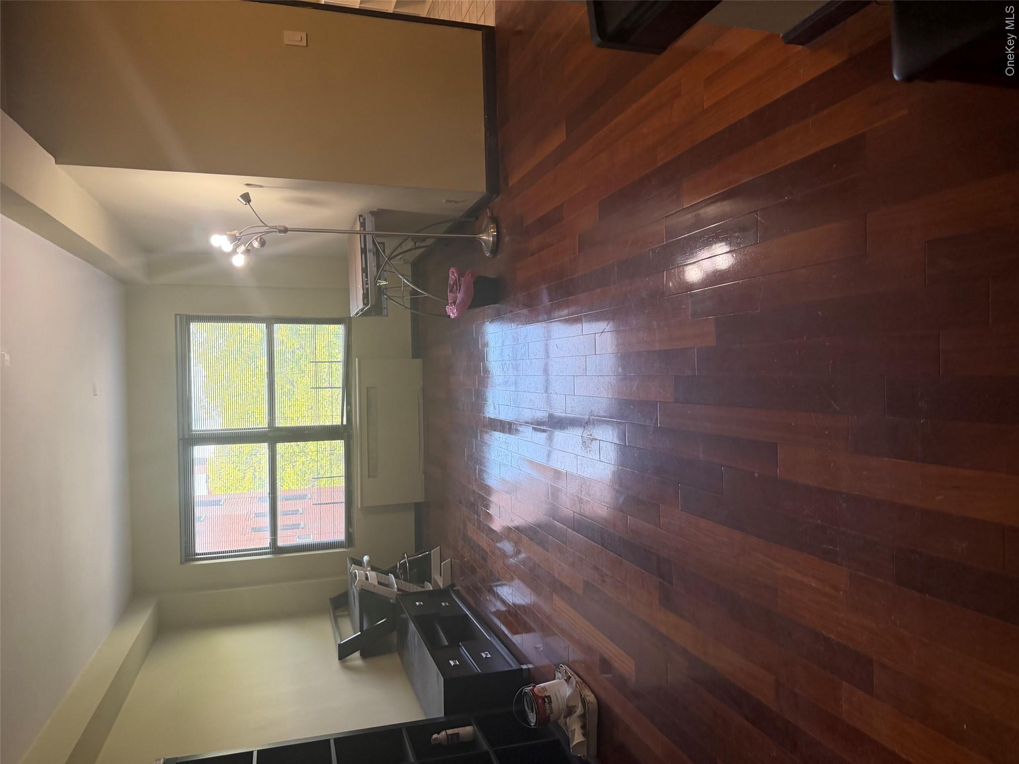 99-32 66th Road, Unit 3AA Queens, NY 11374 - Photo 9 of 9 a view of empty room with wooden floor and fan