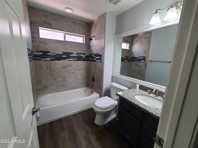 a bathroom with a sink a toilet a mirror and shower