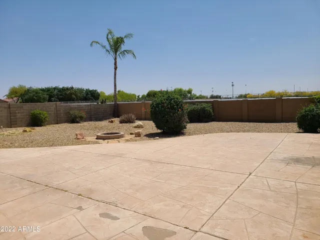 a swimming pool with a yard and palm trees
