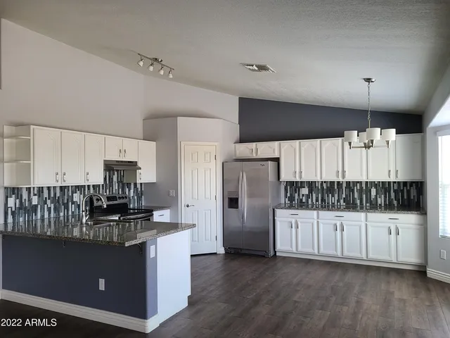 a kitchen with stainless steel appliances a refrigerator and a stove top oven