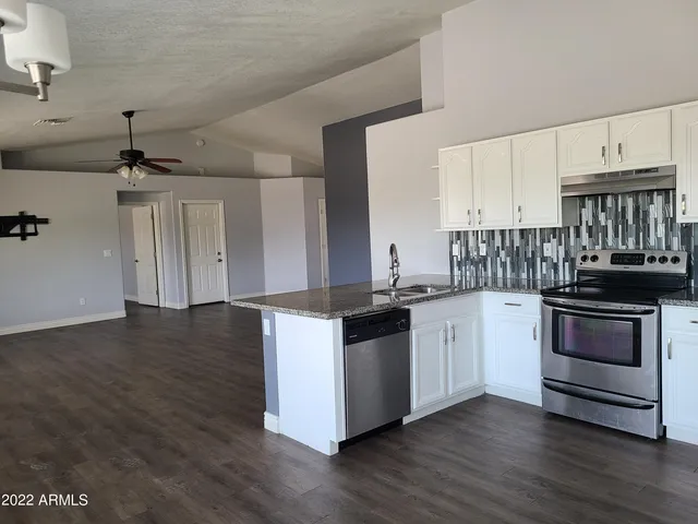 a kitchen with stainless steel appliances granite countertop a stove and a sink