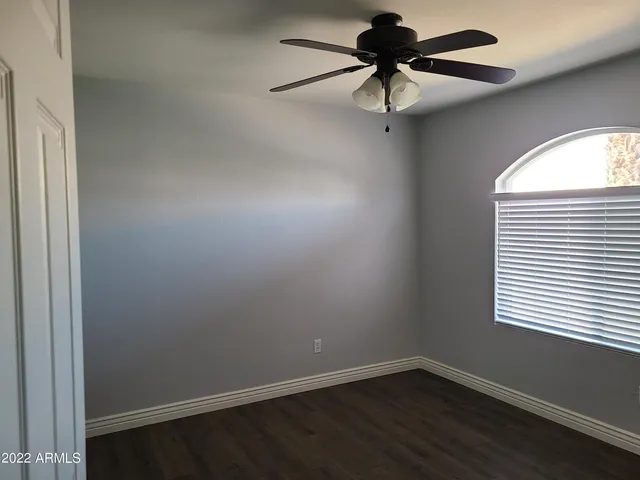 an empty room with a window and a fan