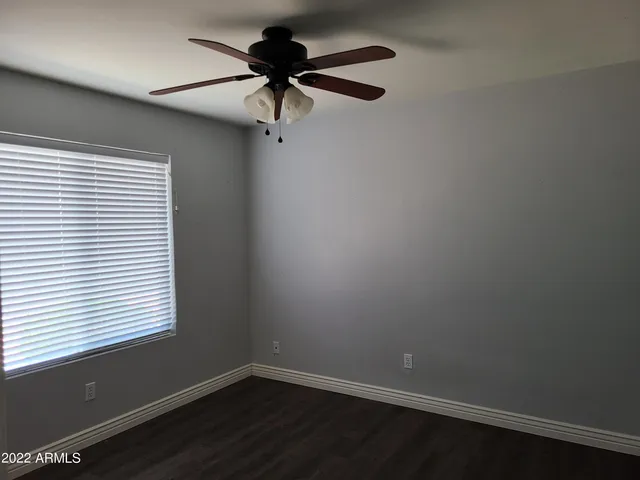 an empty room with a window and a fan