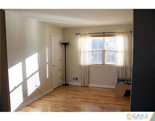 18 Caldwell Road Edison, NJ 08817 - Photo 9 of 11 a view of an empty room with wooden floor and a window