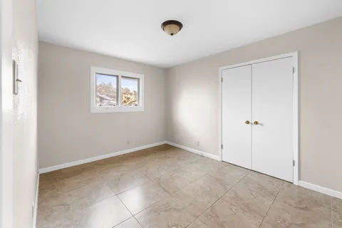 a view of kitchen with cabinets and window