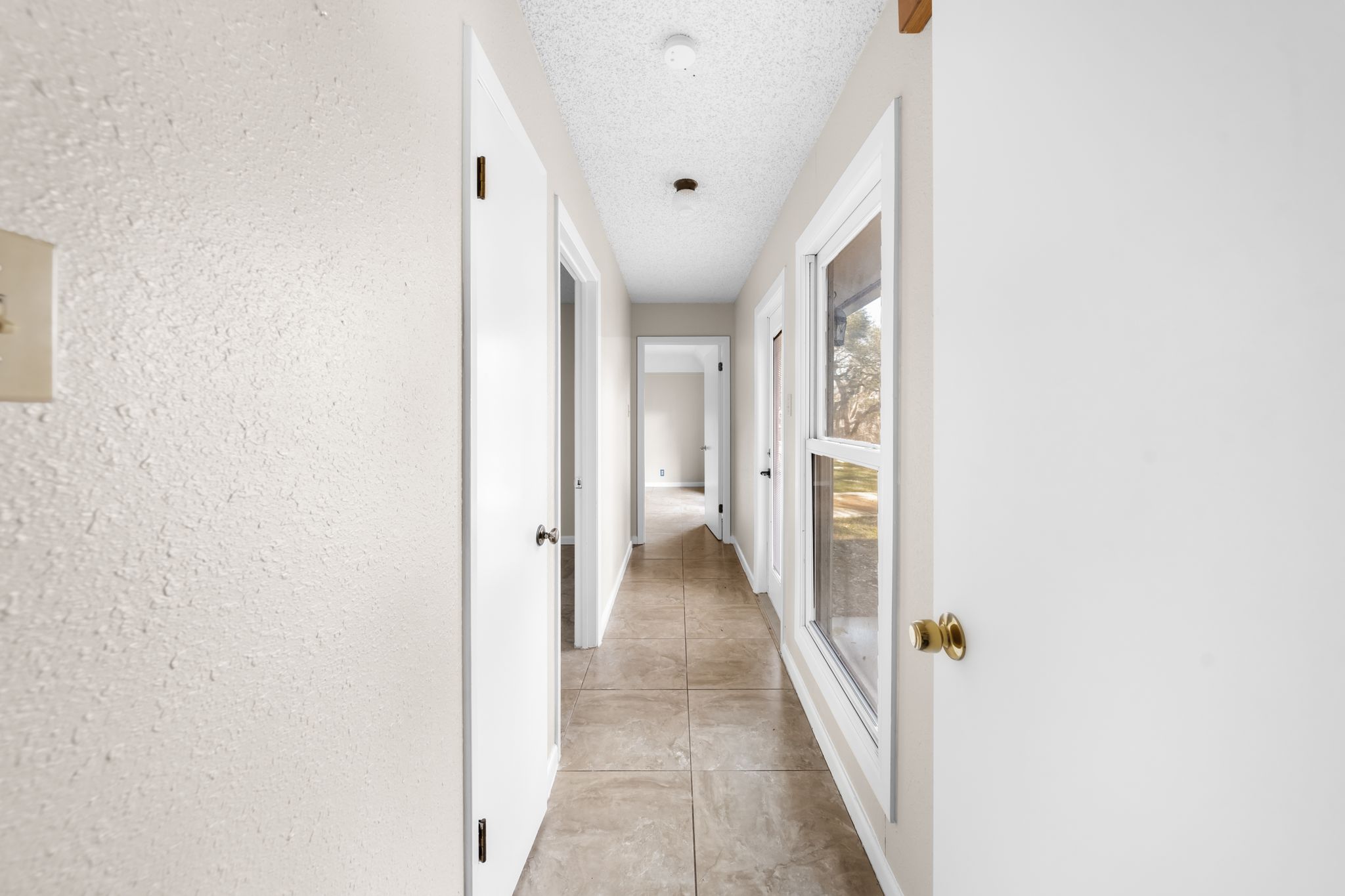 13203 Stillforest Street Austin, TX 78729 - Photo 16 of 33 a view of a hallway with a white walls and a white door