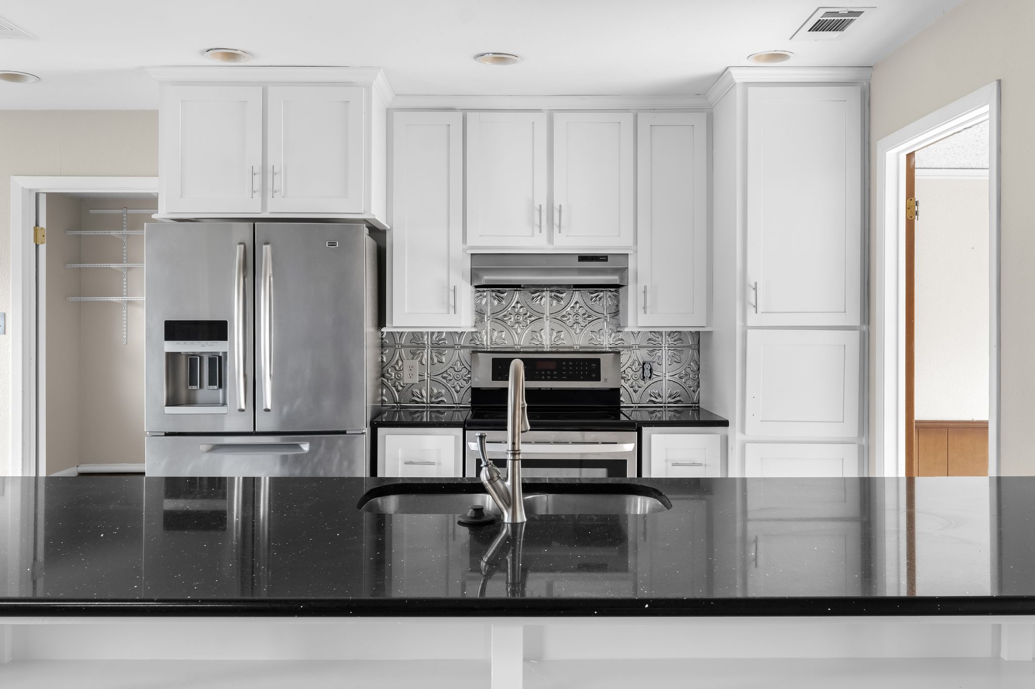 13203 Stillforest Street Austin, TX 78729 - Photo 24 of 33 a kitchen with kitchen island a counter top space cabinets and stainless steel appliances