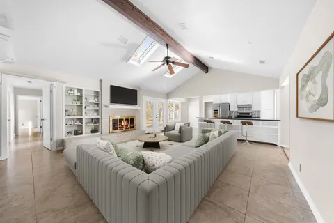 a living room with furniture kitchen view and a fireplace