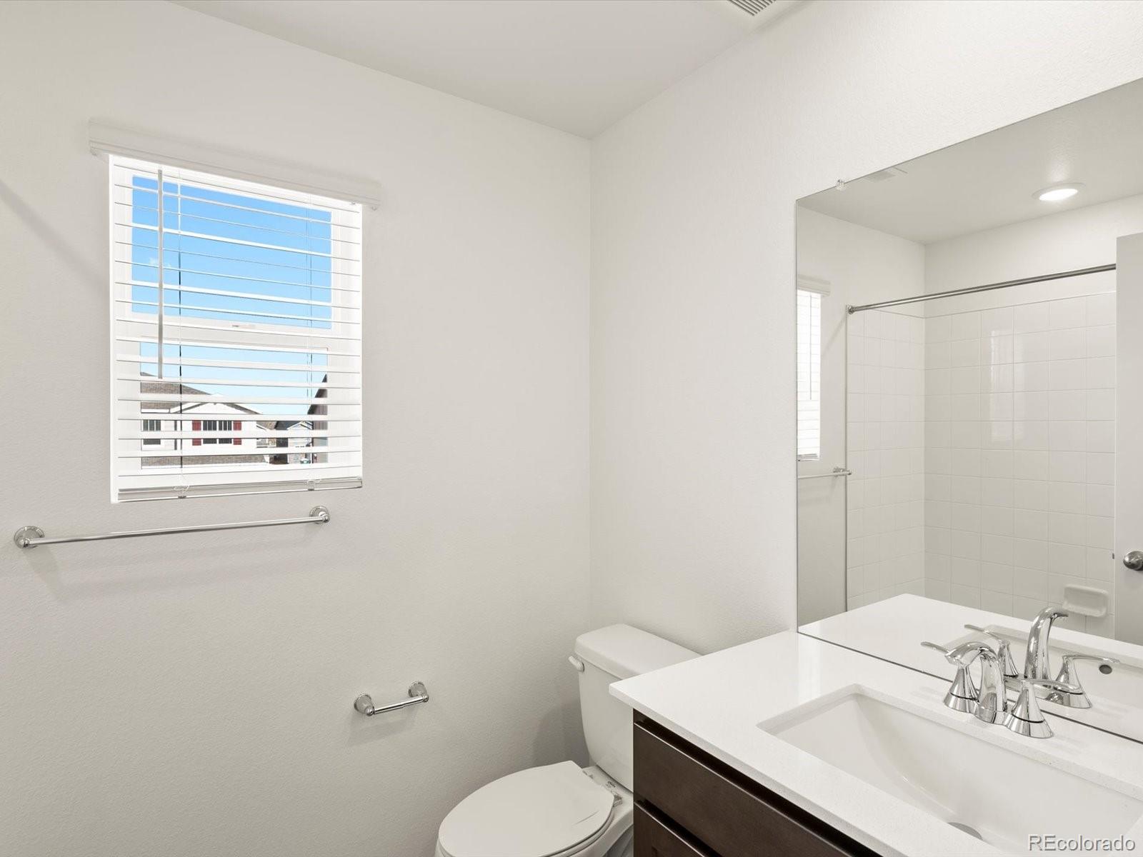 7343 West 27th Street Greeley, CO 80634 - Photo 18 of 29 a bathroom with a sink a toilet and mirror