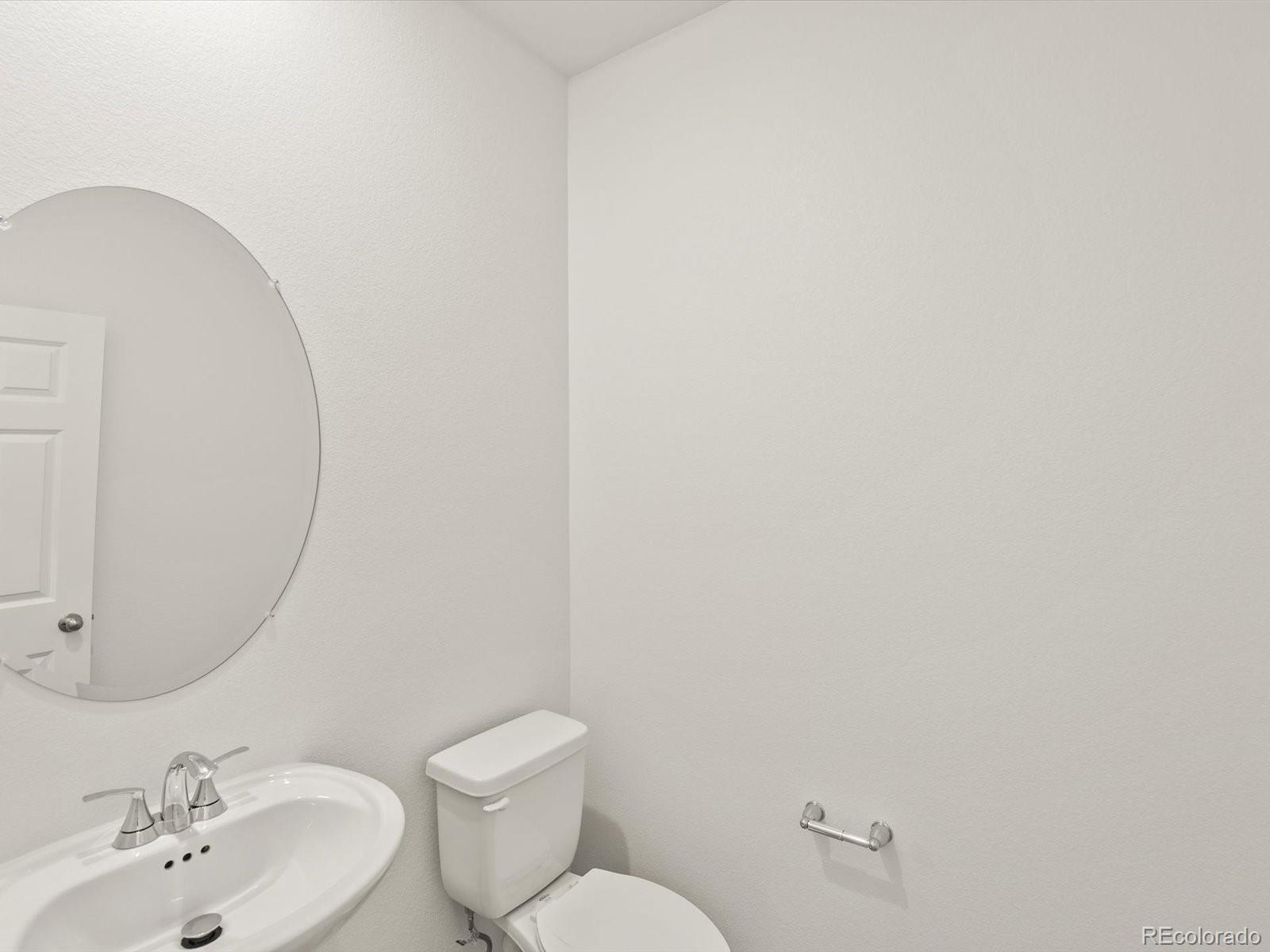 7343 West 27th Street Greeley, CO 80634 - Photo 4 of 29 a bathroom with a toilet sink and mirror