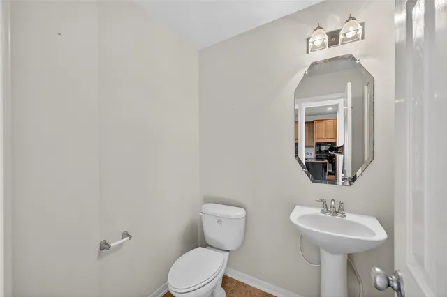 a bathroom with a toilet sink and mirror