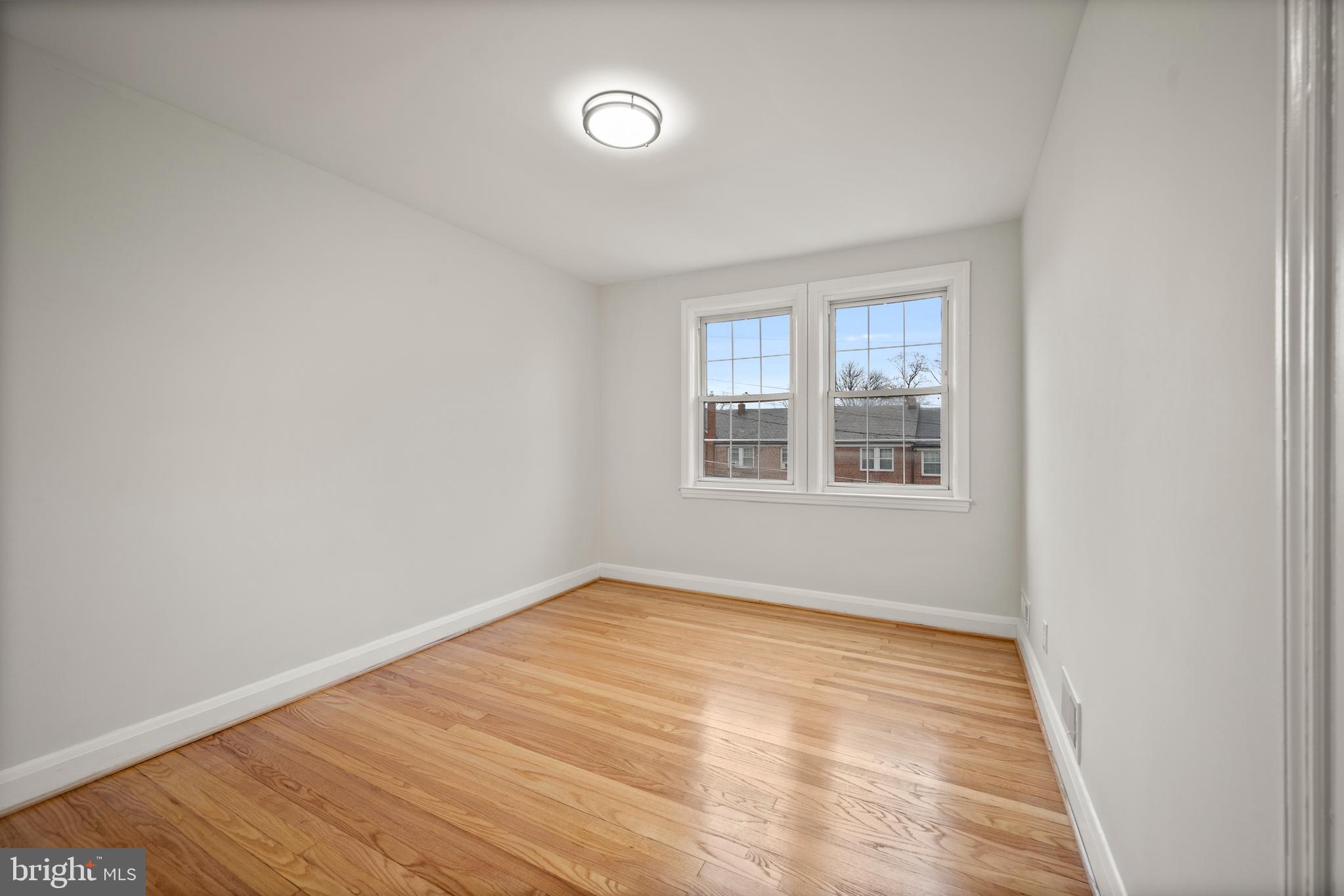 323 Stratford Road Baltimore, MD 21228 - Photo 15 of 35 an empty room with wooden floor and windows