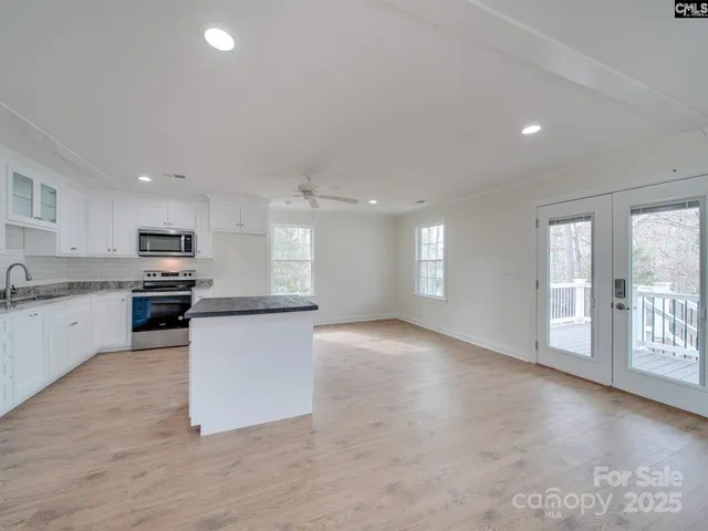 a view of a kitchen with a sink stove top oven and cabinets