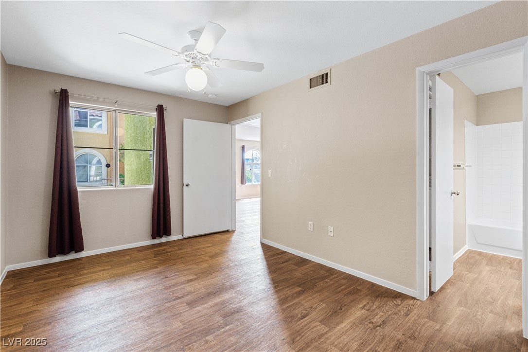 7950 West Flamingo Road, Unit 1039 Las Vegas, NV 89147 - Photo 16 of 26 Unfurnished bedroom featuring wood finished floors and a ceiling fan