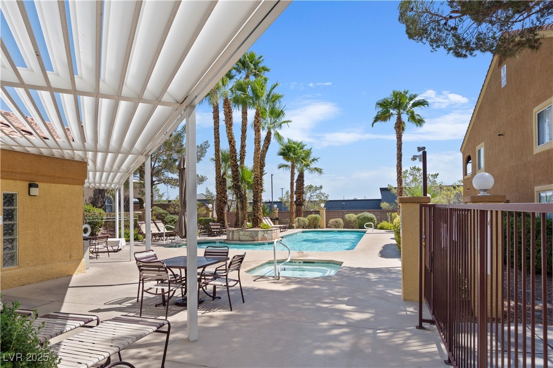7950 West Flamingo Road, Unit 1039 Las Vegas, NV 89147 - Photo 5 of 26 Community pool featuring a hot tub, a patio area, and a pergola