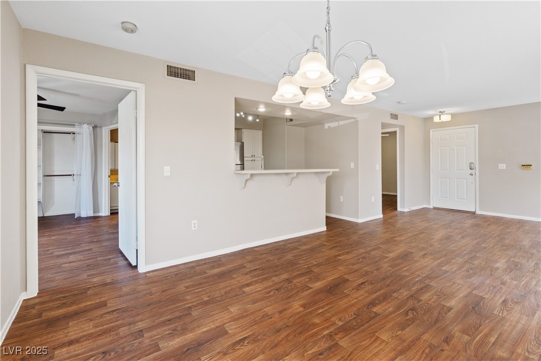 7950 West Flamingo Road, Unit 1039 Las Vegas, NV 89147 - Photo 9 of 26 Unfurnished living room with dark wood-type flooring and a chandelier