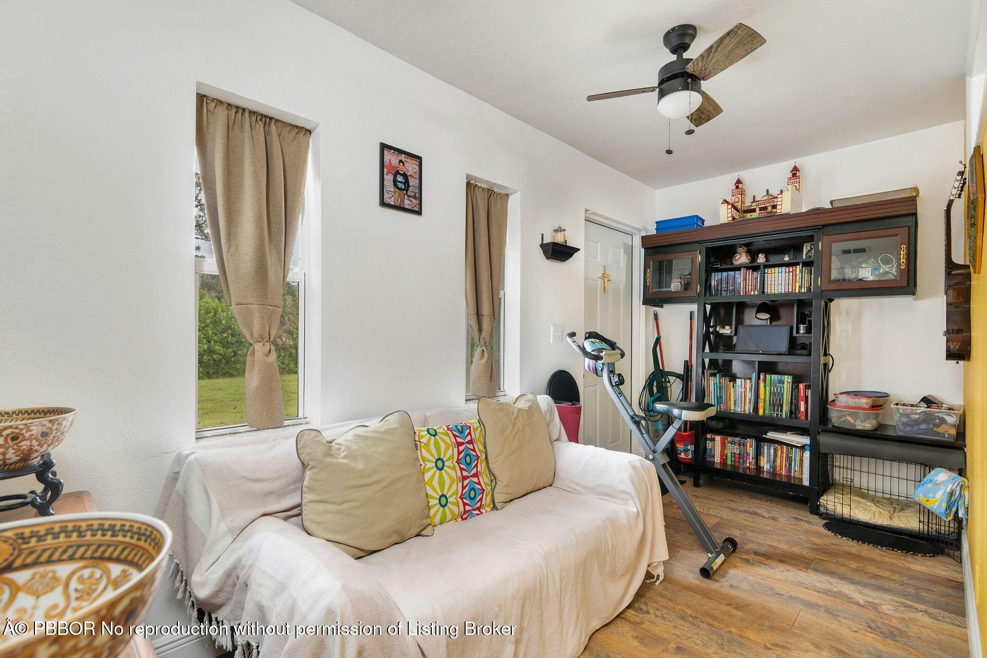 2770 E Road Loxahatchee, FL 33470 - Photo 30 of 51 a bedroom with furniture and a chandelier