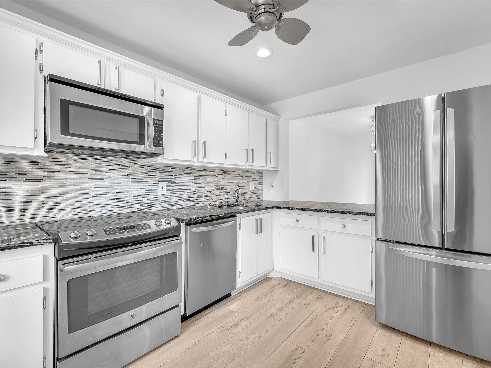 9290 Vista Del Lago, Unit E Boca Raton, FL 33428 - Photo 15 of 39 Kitchen with glass tile backsplash