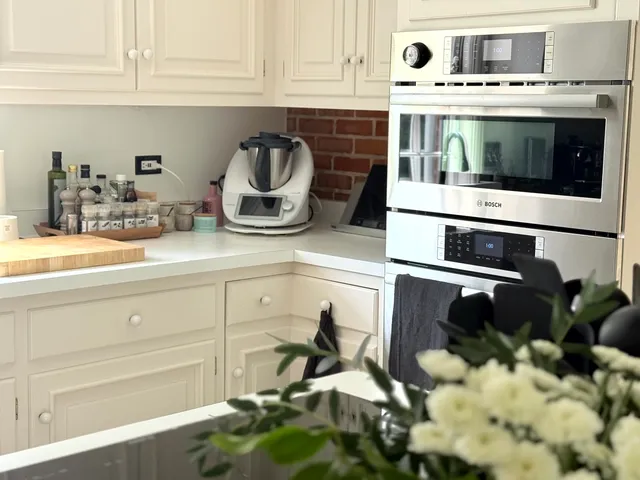 a kitchen with a stove and white cabinets