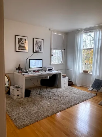 a view of a workspace with furniture and a window