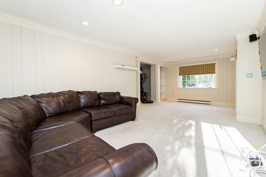 66 Suffolk Road Wellesley, MA 02481 - Photo 19 of 29 a living room with a couch and a floor to ceiling window