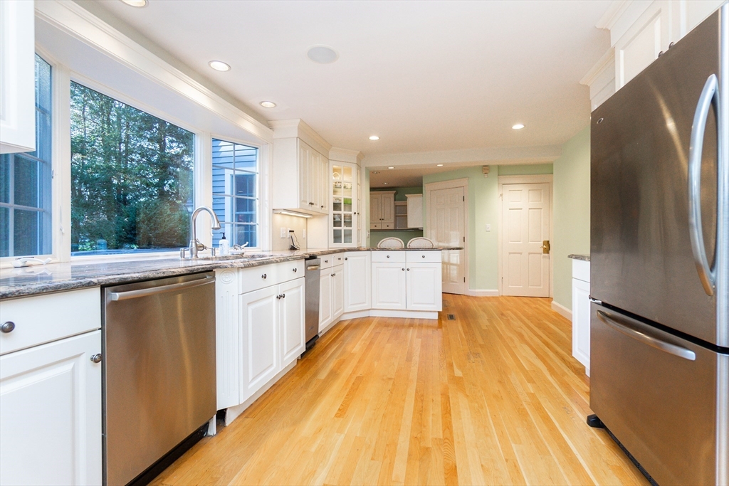 66 Suffolk Road Wellesley, MA 02481 - Photo 8 of 29 a large kitchen with stainless steel appliances granite countertop a refrigerator a sink dishwasher a stove and white countertops with wooden floor